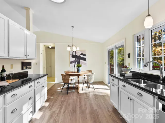 a kitchen with stainless steel appliances a kitchen island hardwood floor sink stove dining table and chairs