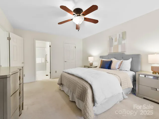 a spacious bedroom with a bed and a ceiling fan