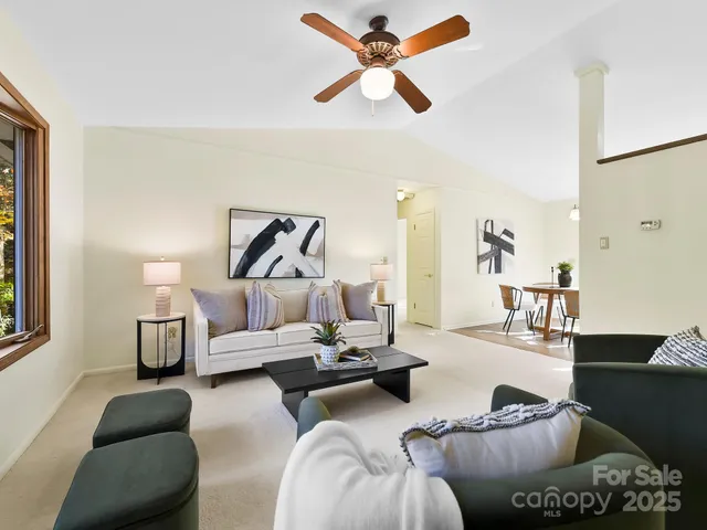 a living room with furniture and a ceiling fan
