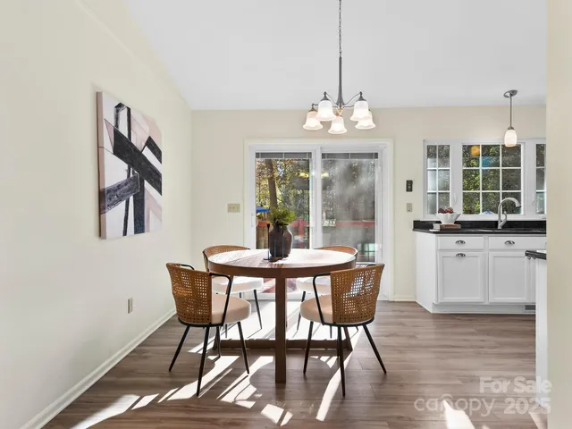 a dining room with furniture a chandelier and wooden floor