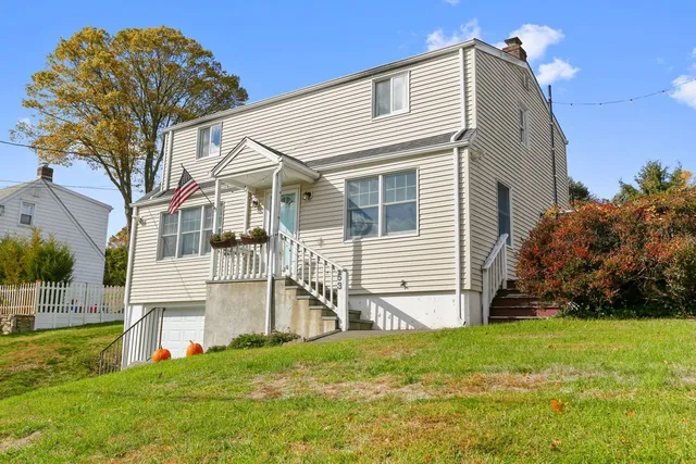 a view of a white house with a big yard and large trees