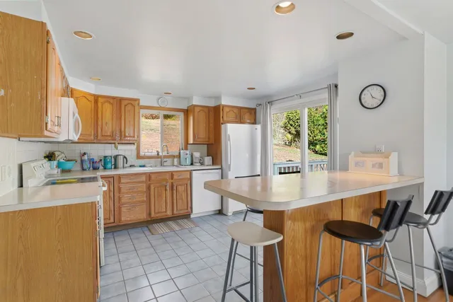 a kitchen with granite countertop white cabinets and stainless steel appliances