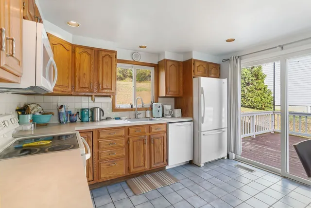 a kitchen with cabinets appliances a sink and a window