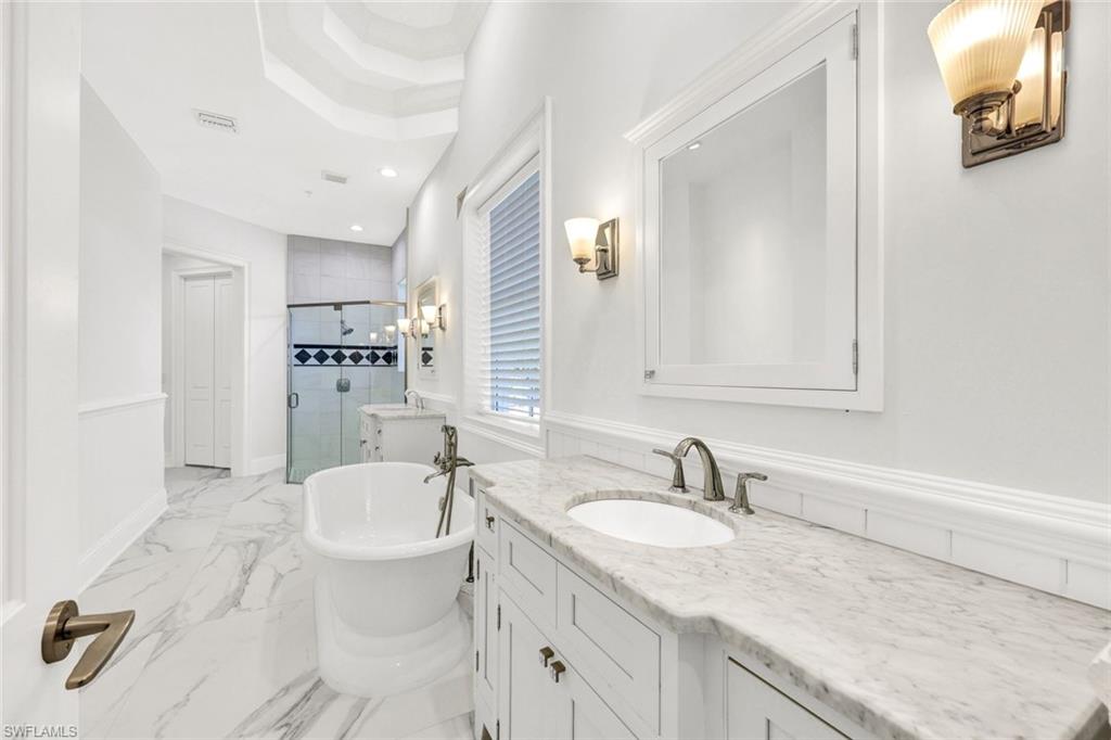 699 Fairway Terrace Naples, FL 34103 - Photo 21 of 46 a bathroom with double vanity sink a mirror and a bathtub