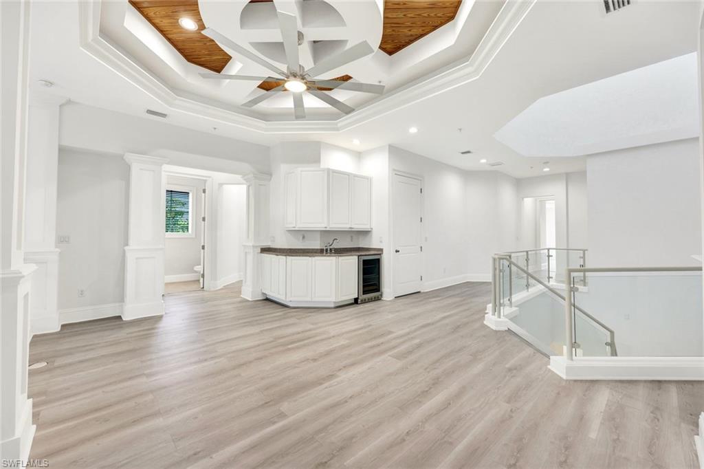 699 Fairway Terrace Naples, FL 34103 - Photo 22 of 46 a view of an empty room with wooden floor and a ceiling fan