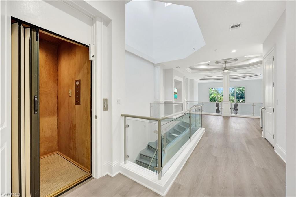 699 Fairway Terrace Naples, FL 34103 - Photo 25 of 46 a view of entryway with wooden floor and a chandelier