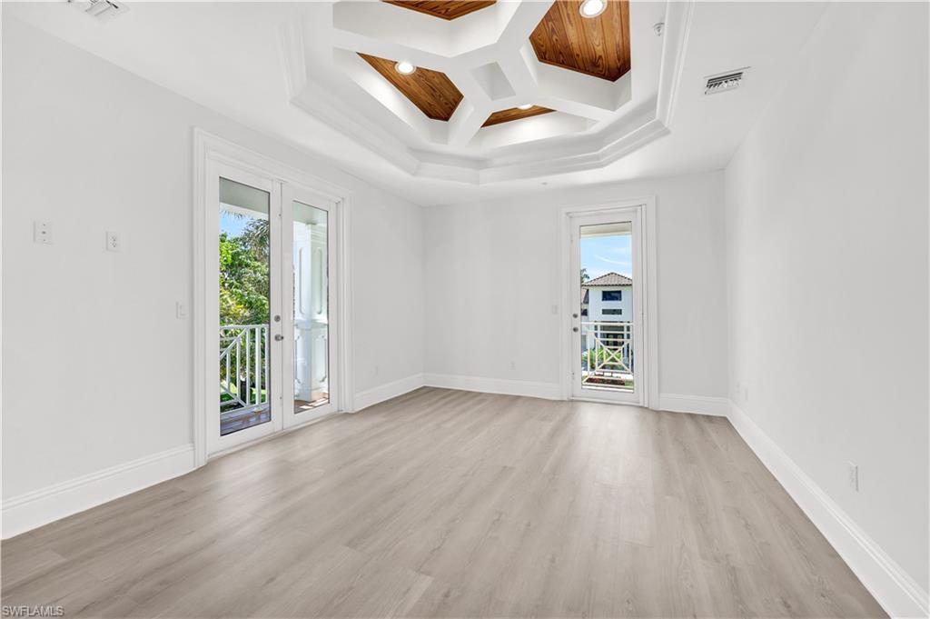 699 Fairway Terrace Naples, FL 34103 - Photo 26 of 46 an empty room with wooden floor and windows