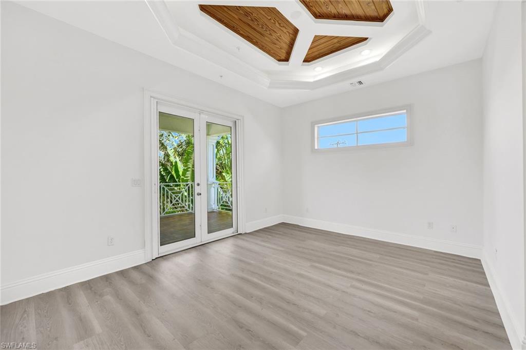699 Fairway Terrace Naples, FL 34103 - Photo 33 of 46 an empty room with wooden floor and windows