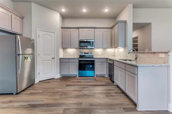 a kitchen with stainless steel appliances granite countertop a refrigerator and a sink