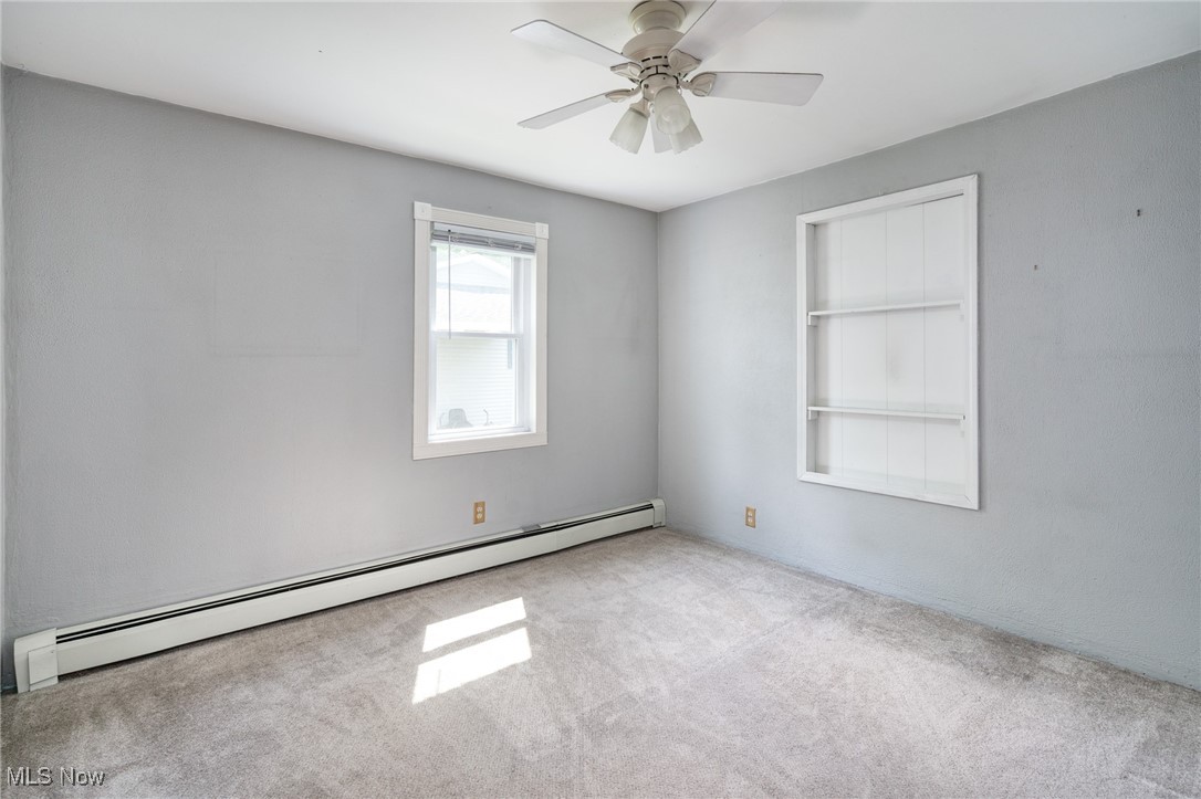 46125 Middle Ridge Road Amherst, OH 44001 - Photo 24 of 33 Spare room featuring a baseboard radiator, carpet flooring, and a ceiling fan