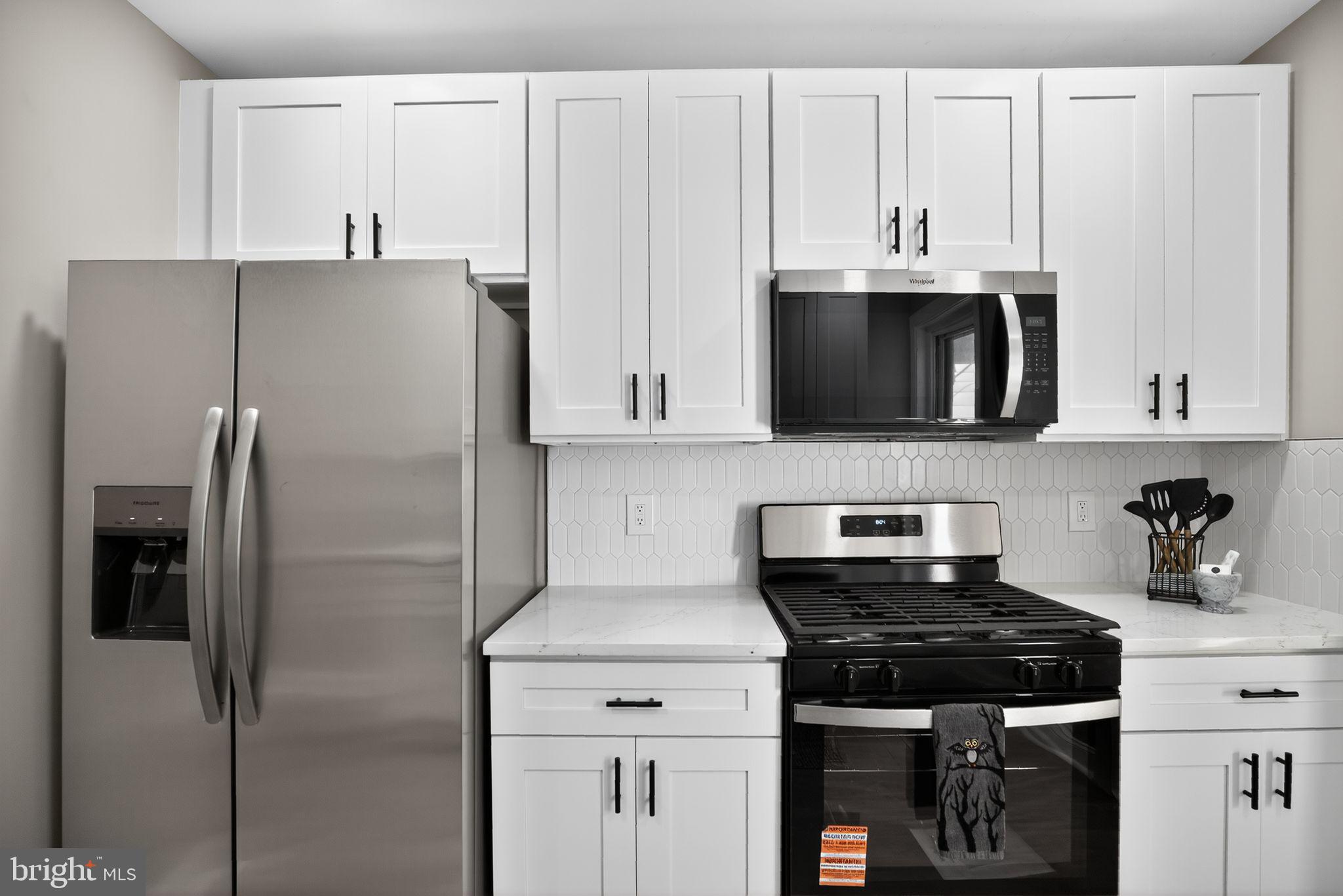 258 West Sheldon Street Philadelphia, PA 19120 - Photo 14 of 29 a kitchen with stainless steel appliances a refrigerator a stove top oven and cabinets