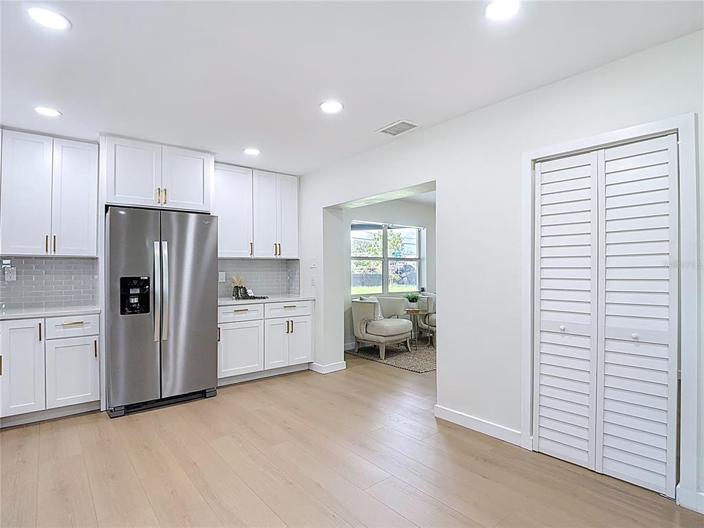 2402 East 148th Avenue Lutz, FL 33549 - Photo 20 of 71 a kitchen with granite countertop a refrigerator a sink a stove and white cabinets
