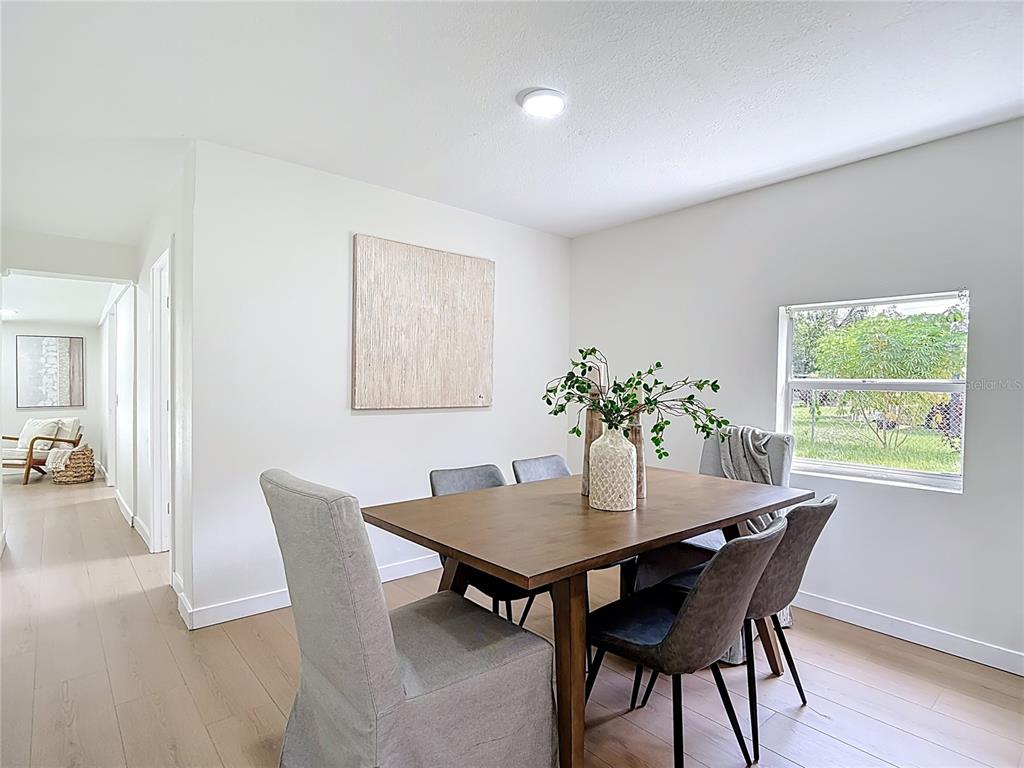2402 East 148th Avenue Lutz, FL 33549 - Photo 22 of 71 a view of a dining room with furniture and wooden floor