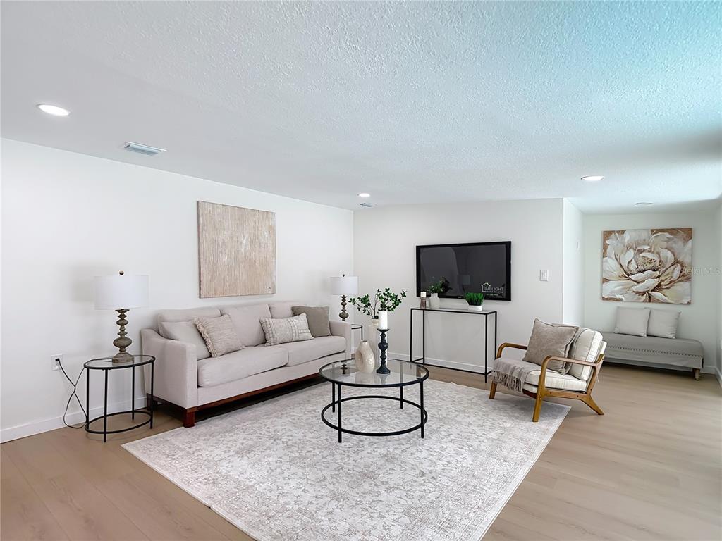 2402 East 148th Avenue Lutz, FL 33549 - Photo 26 of 71 a living room with furniture a rug and a flat screen tv