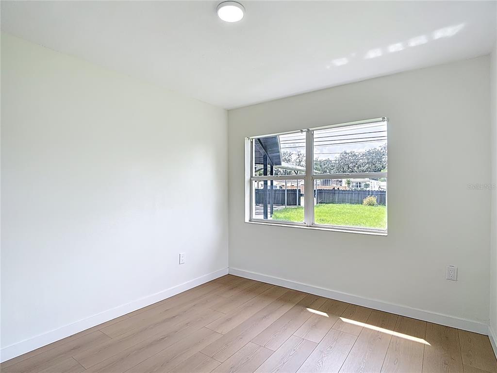 2402 East 148th Avenue Lutz, FL 33549 - Photo 31 of 71 an empty room with wooden floor and windows