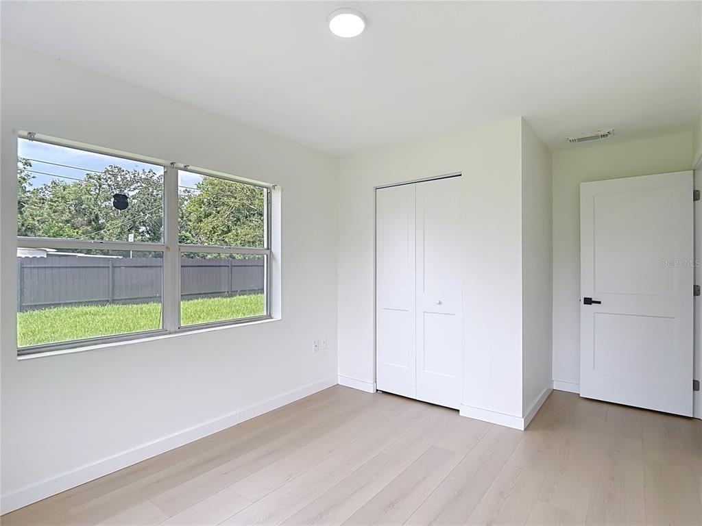 2402 East 148th Avenue Lutz, FL 33549 - Photo 33 of 71 a view of an empty room with wooden floor and a window