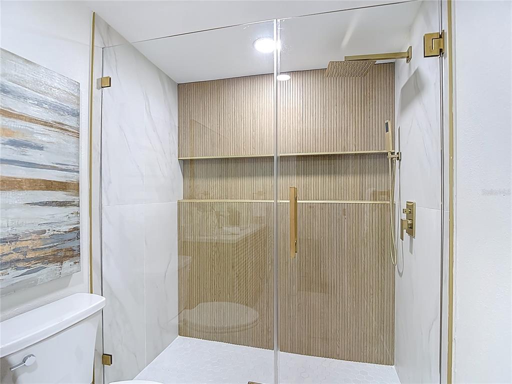 2402 East 148th Avenue Lutz, FL 33549 - Photo 39 of 71 a bathroom with a shower and a toilet