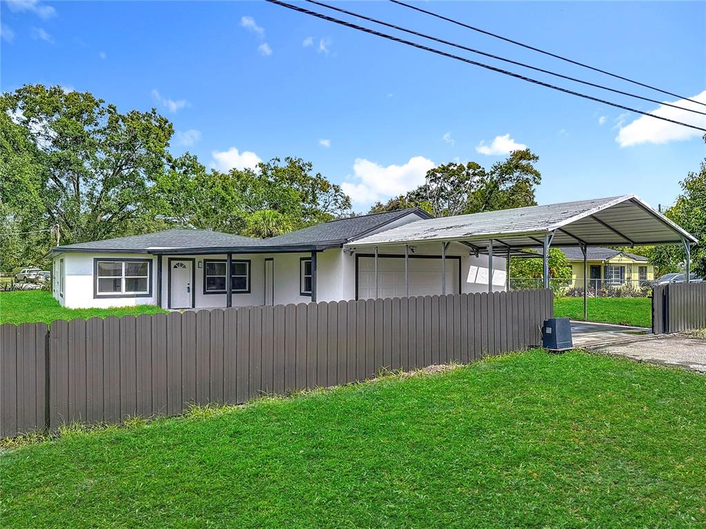 2402 East 148th Avenue Lutz, FL 33549 - Photo 63 of 71 a front view of a house with a yard and potted plants