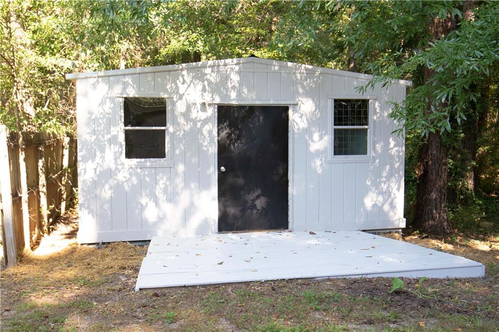 95 Lee Road Salem, AL 36874 - Photo 9 of 13 Detached storage building featuring a black entry door, two windows, and an exterior white painted finish