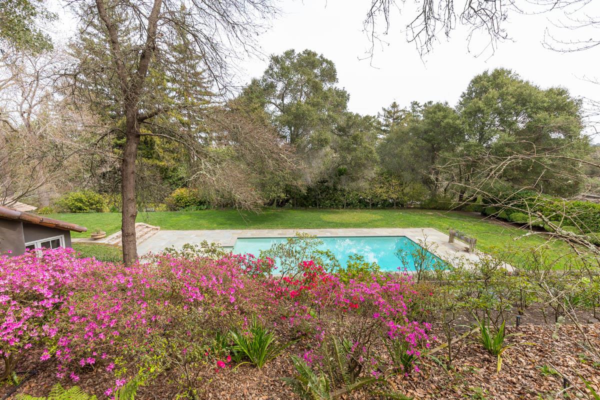 1475 Portola Road Woodside, CA 94062 - Photo 11 of 12 a view of a swimming pool with lawn chairs under an umbrella