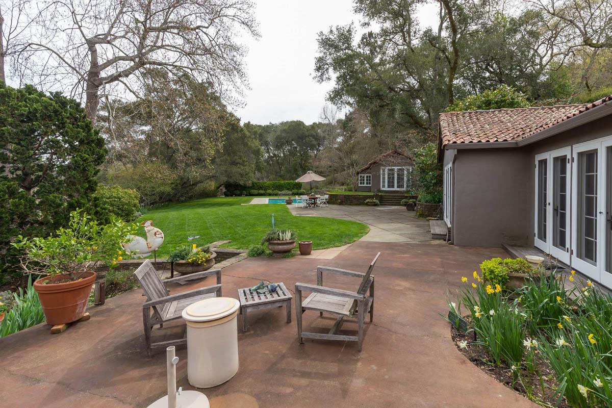 1475 Portola Road Woodside, CA 94062 - Photo 5 of 12 a view of a patio with table and chairs potted plants and a large tree