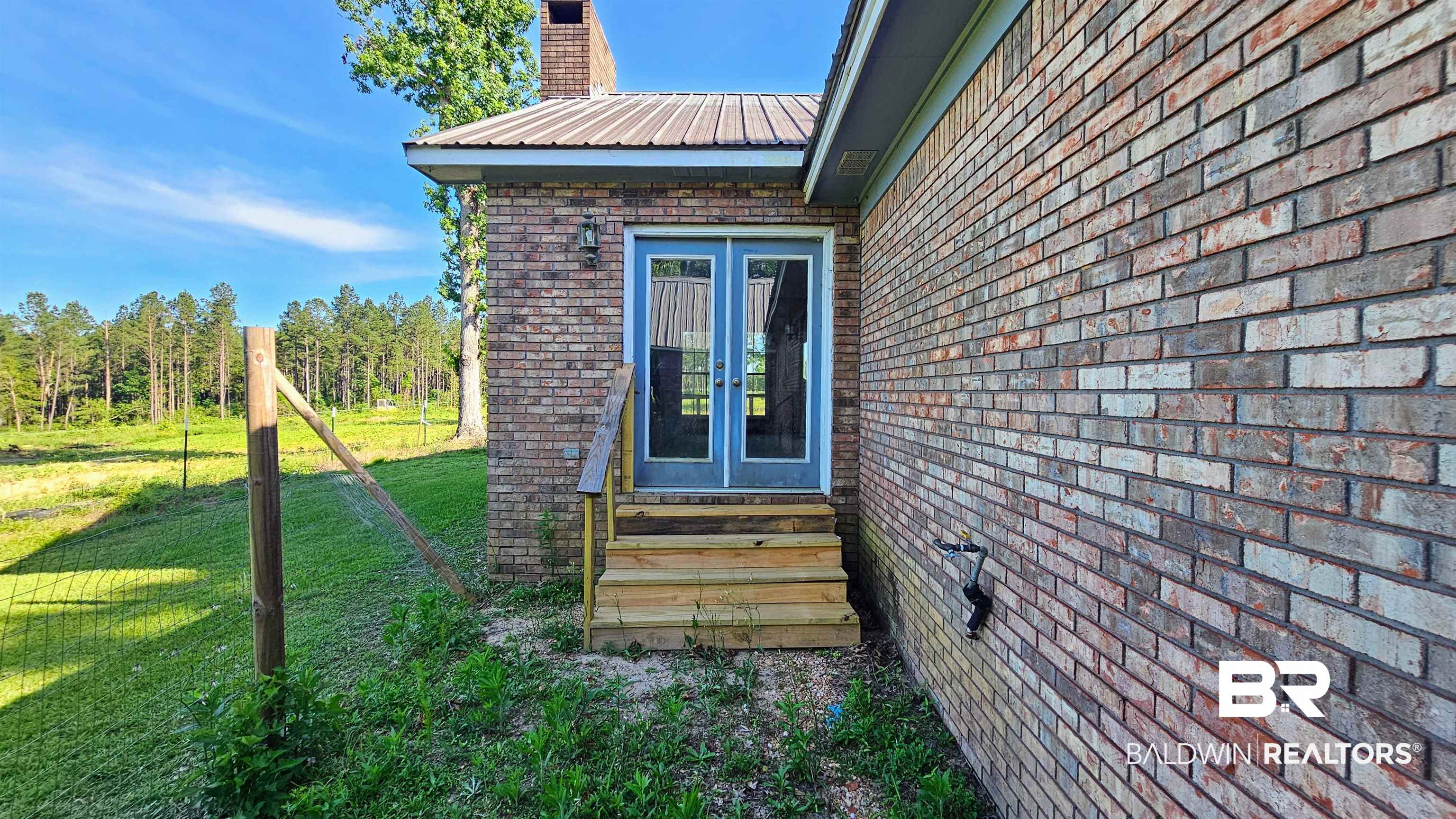 18824 Highway 41 Brewton, AL 36426 - Photo 10 of 40 Brick exterior with a metal roof and a prominent chimney