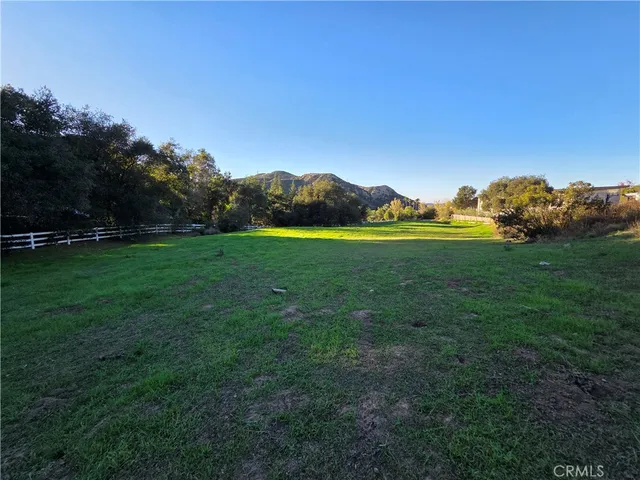 a view of grassy field with mountain in background