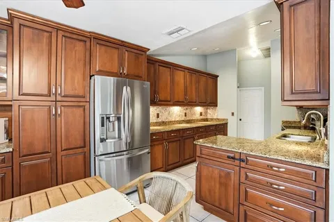 a kitchen with granite countertop stainless steel appliances a refrigerator and cabinets