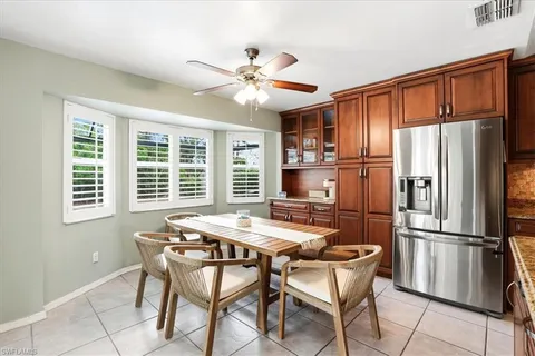 a kitchen with stainless steel appliances granite countertop a refrigerator a stove a sink dishwasher a dining table and chairs with wooden floor