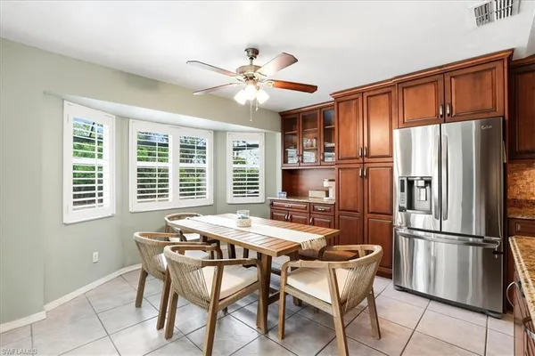 a kitchen with stainless steel appliances granite countertop a refrigerator a stove a sink dishwasher a dining table and chairs with wooden floor