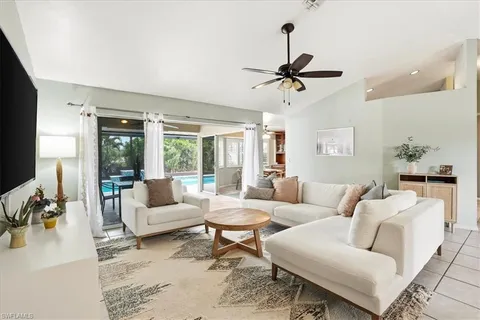 a living room with furniture ceiling fan and a window
