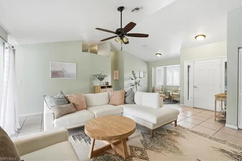 a living room with furniture a ceiling fan and a rug