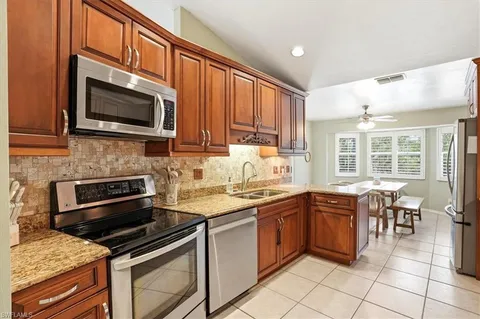 a kitchen with stainless steel appliances granite countertop a stove microwave and sink