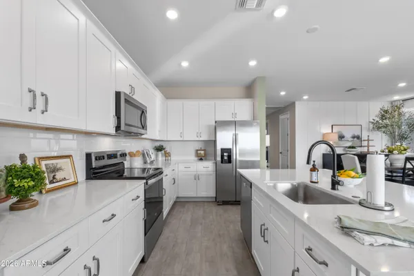 a kitchen with stainless steel appliances granite countertop a sink a stove and cabinets