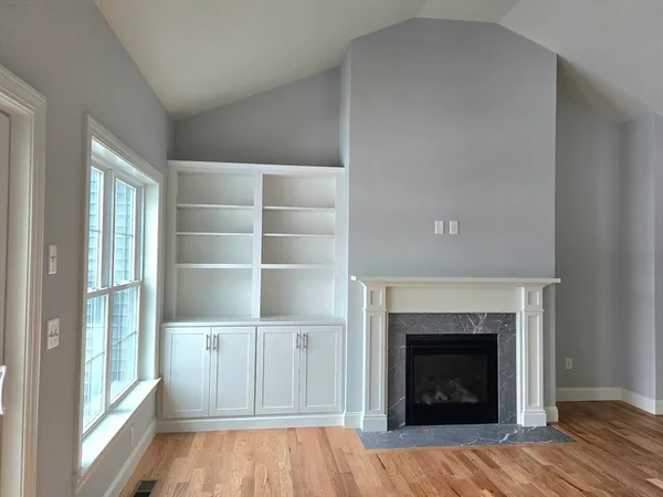 a view of a livingroom with a fireplace and window