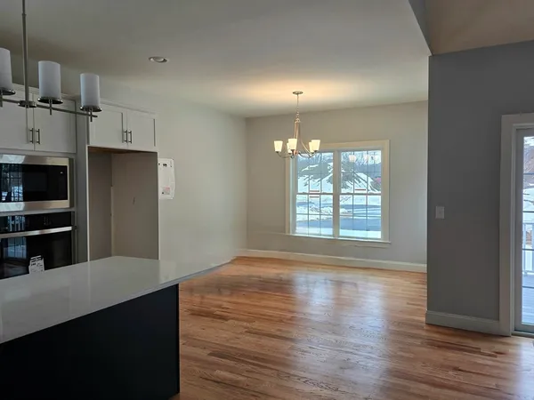 a kitchen with stainless steel appliances a refrigerator and a wooden floor