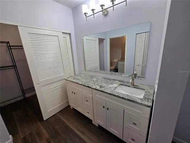 a bathroom with a granite countertop sink and a mirror