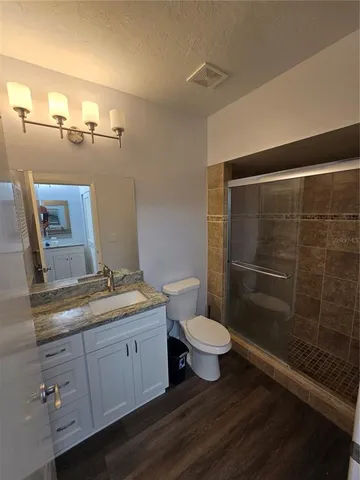 a bathroom with a granite countertop sink toilet and shower