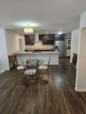 a kitchen with stainless steel appliances a dining table chairs microwave and sink