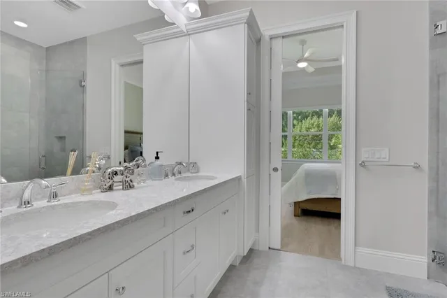 a en suite bathroom with a double vanity sink a mirror and a shower