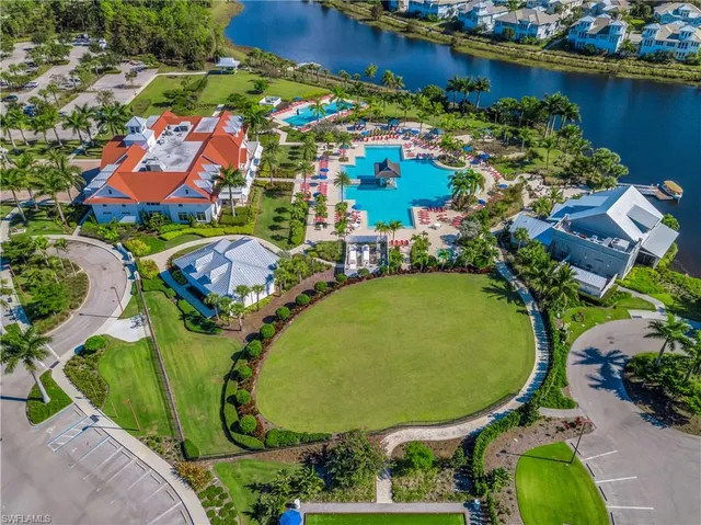 an aerial view of a residential houses with outdoor space and a lake view