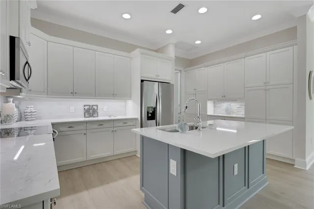 a kitchen with a sink a stove a refrigerator and white cabinets