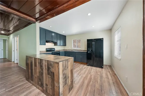 a kitchen with stainless steel appliances granite countertop a refrigerator a stove top oven a sink and dishwasher