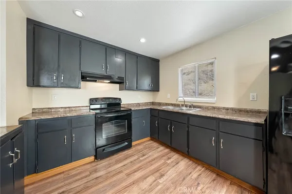 a kitchen with granite countertop wooden cabinets and a stove top oven