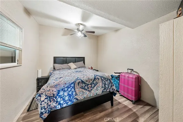 a bedroom with a bed chandelier and a window