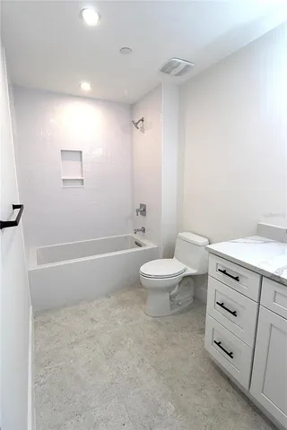 a bathroom with a granite countertop toilet and a sink