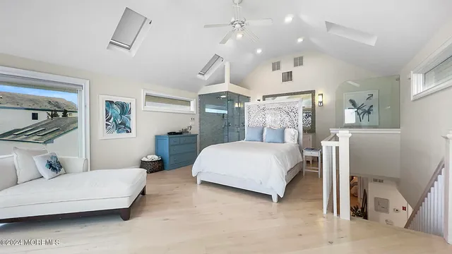 a spacious bedroom with a bed a couch and a chandelier