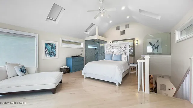 a spacious bedroom with a bed a couch and dresser