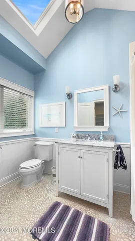 a bathroom with a toilet sink and mirror