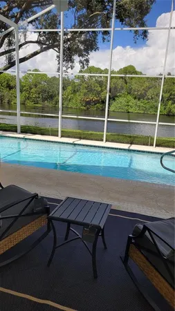 a view of a backyard with lawn chairs and a barbeque